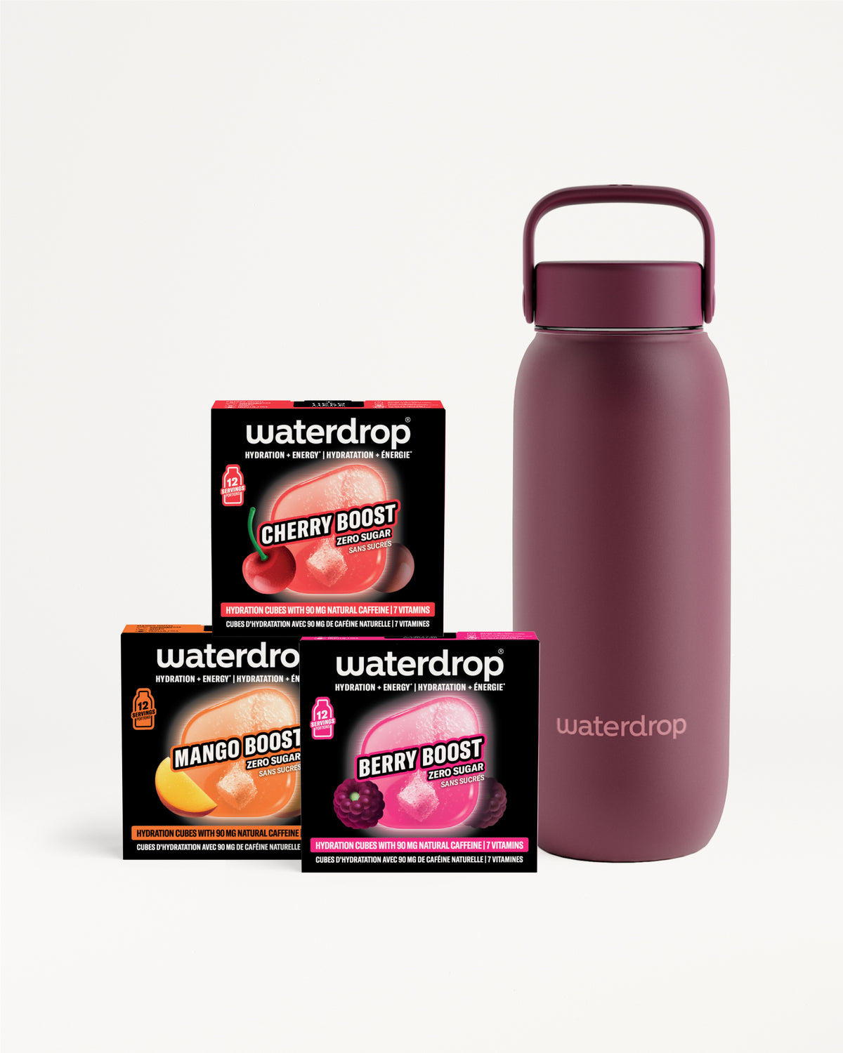 Botella de agua aislante magenta con asa junto a tres pequeñas cajas negras.