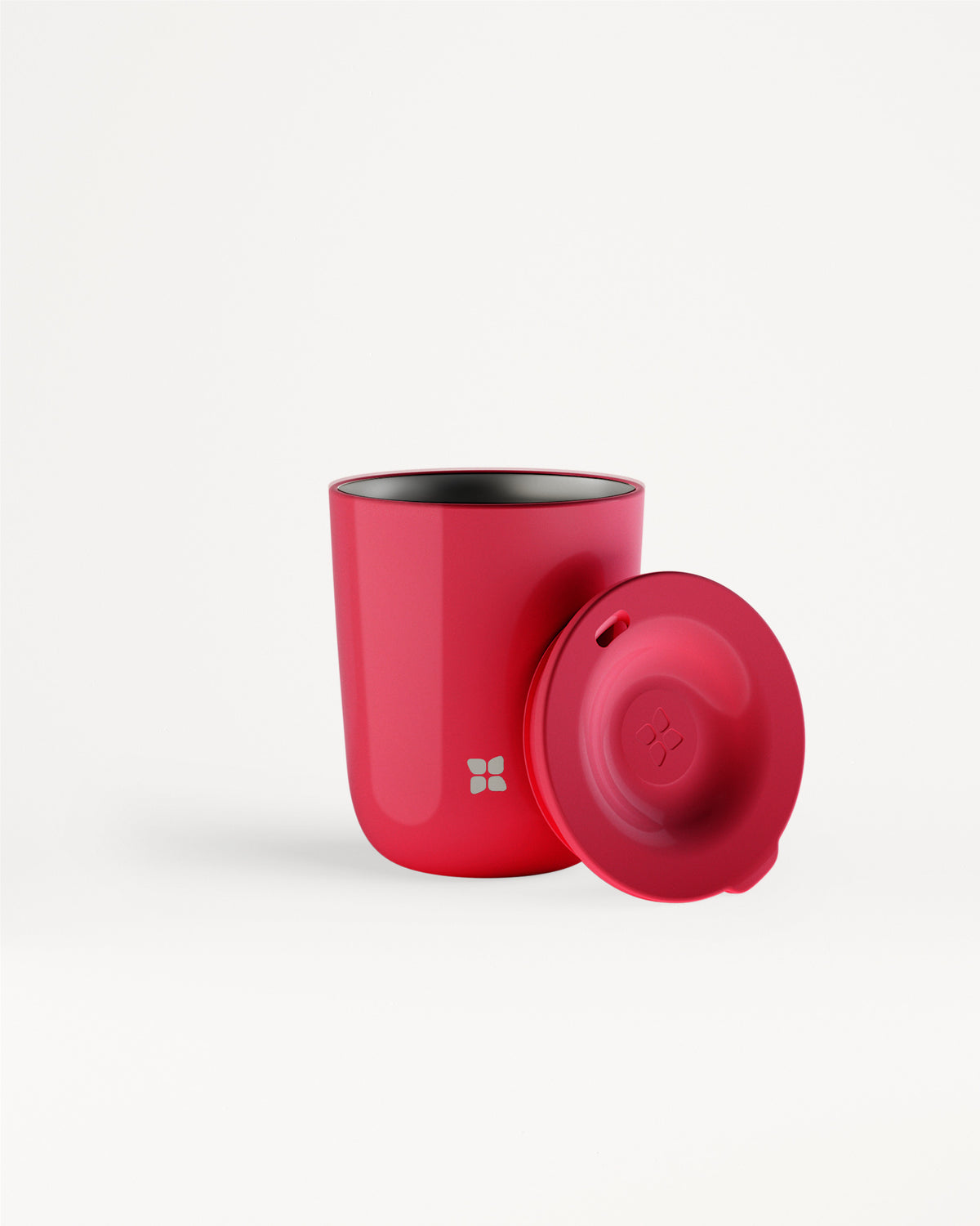 Taza roja con tapa roja a juego sobre fondo blanco.