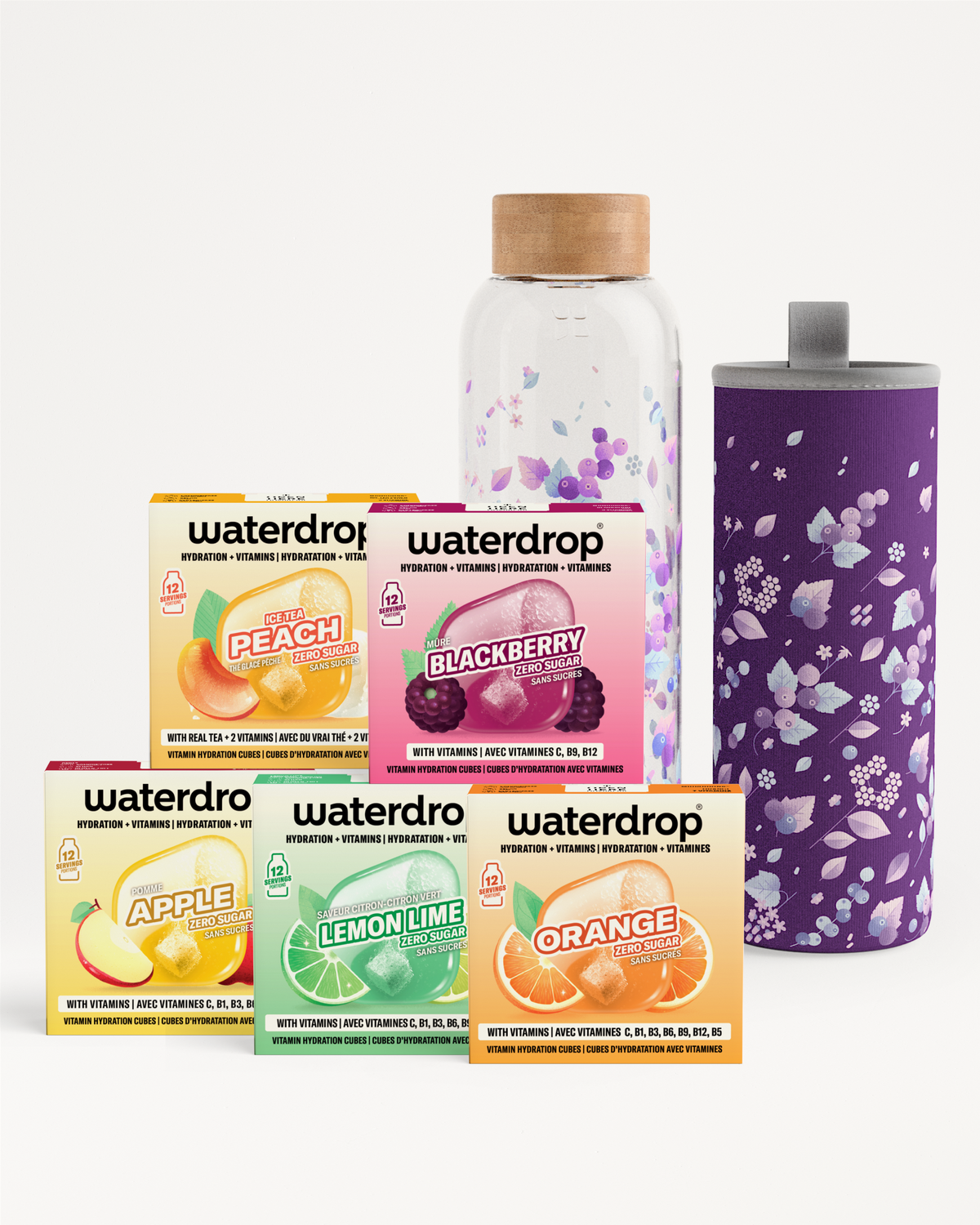 Seleccion de sobres de sabor para bebidas en cajas coloridas, junto a una botella de vidrio con corcho y un vaso térmico morado con flores.