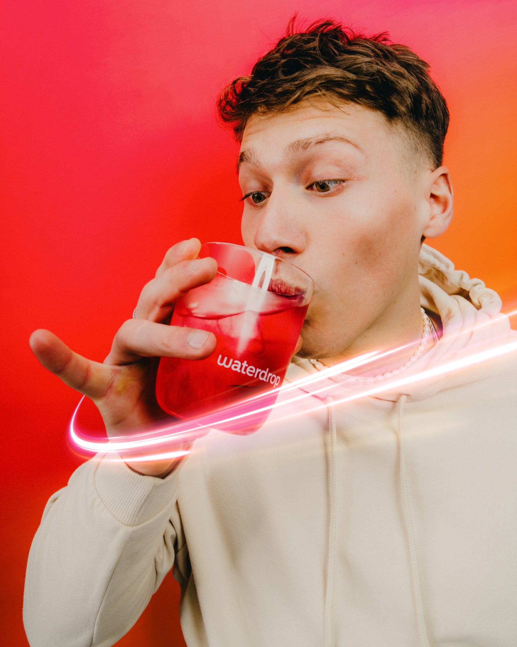 Person sipping Microenergy Booster Set drink from waterdrop® glass.