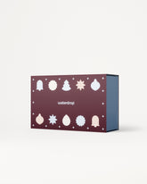 Caja regalo morada con iconos blancos navideños en la tapa y interior azul.