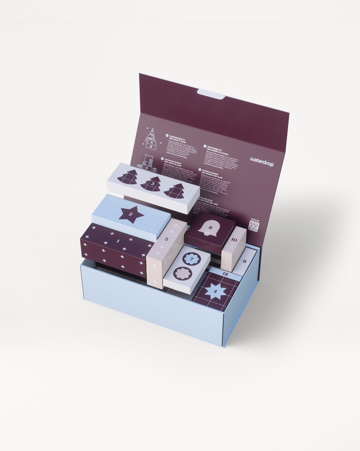 Caja de regalo de tres niveles en azul claro con tapa morada abierta para descubrir varias cajas pequeñas decorativas en colores coordinados.