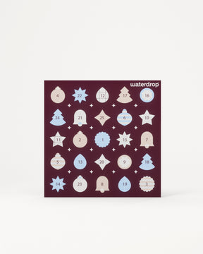 Calendario de Adviento con 24 puertas numeradas en un cuadrado morado oscuro sobre un fondo claro.