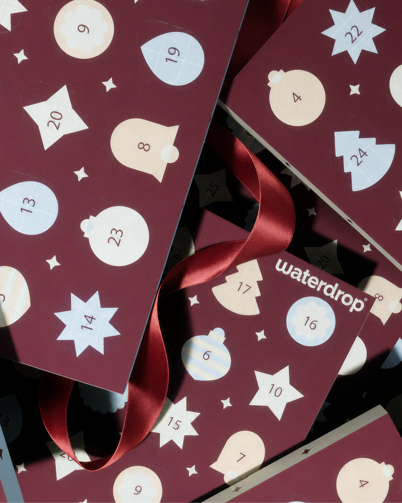 Calendario de Adviento marrón con puertas numeradas y compartimentos en forma de estrella, atado con lazos rojos.