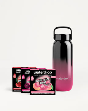 Botella reutilizable con gradiente negro a rosa y varios sobres de sabor.