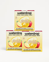 Tres cajas de Waterdrop sabor manzana para hidratación con vitaminas apiladas en forma de pirámide.