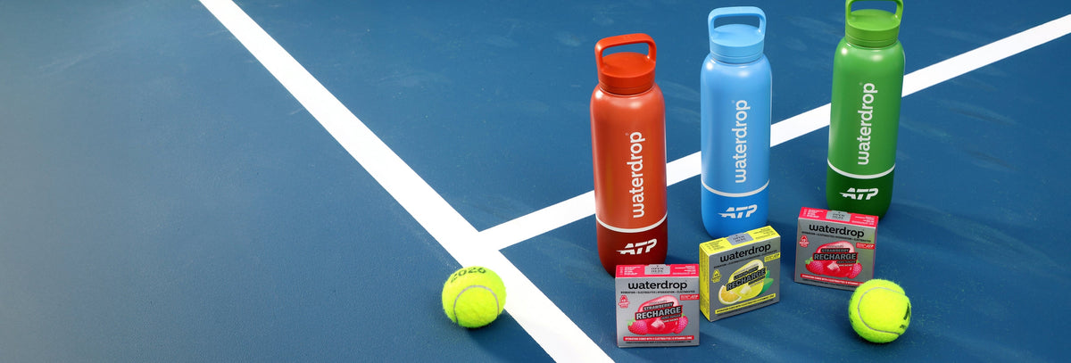 Botellas deportivas de colores, pelotas de tenis y pequeños paquetes dispuestos en una pista azul.