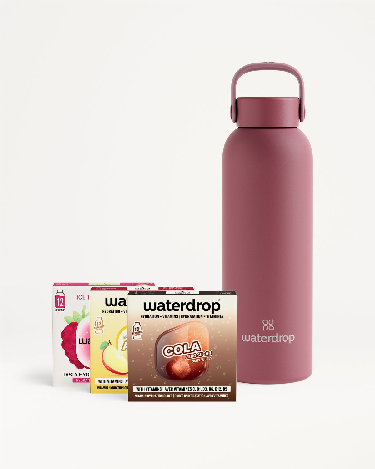 Botella rosa reutilizable con asa junto a sobres de mezclas para bebidas.