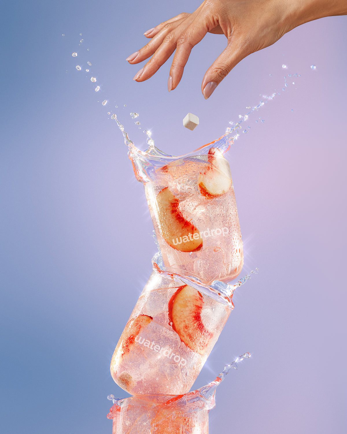 Cubos de hielo apilados con rodajas de fresa y una mano dejando caer un cubo, con chorros de agua.