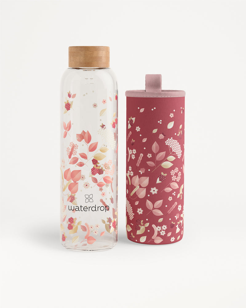 Dos botellas de agua con estampado floral, una transparente con tapa de madera y otra rosa con tapa a juego.