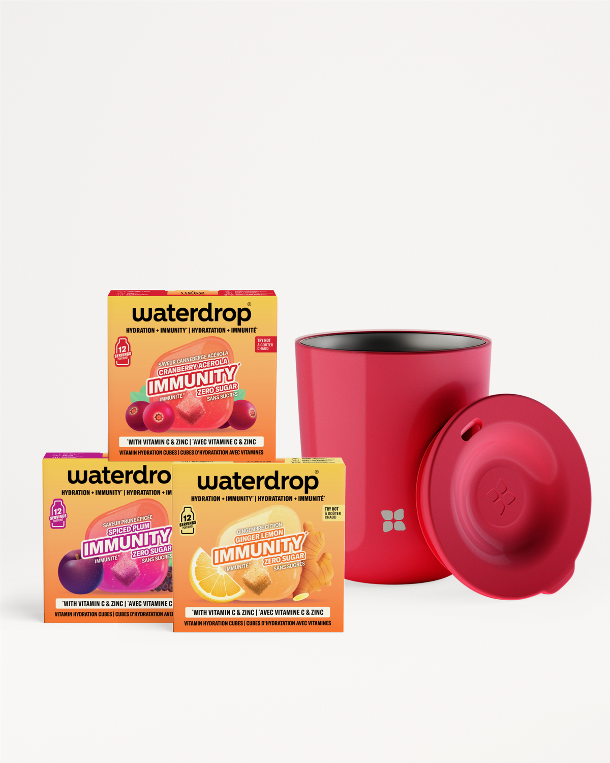 Tres cajas coloridas de sobres de vitaminas dispuestas junto a una botella cilíndrica roja con tapa roja a juego.