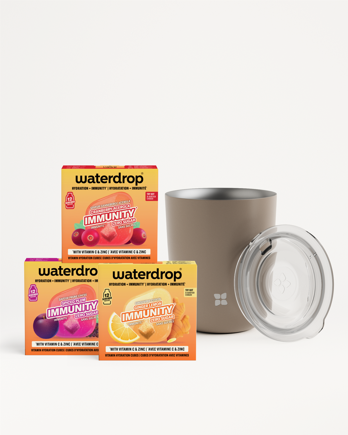 Conjunto de tres cajas de bebidas coloridas y una taza de acero inoxidable con tapa transparente.
