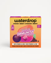 Caja amarilla y morada de Waterdrop con cubos de vitaminas para la inmunidad sobre fondo blanco.