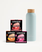 Cajas de sabores Waterdrop y una botella azul claro con tapa de madera.